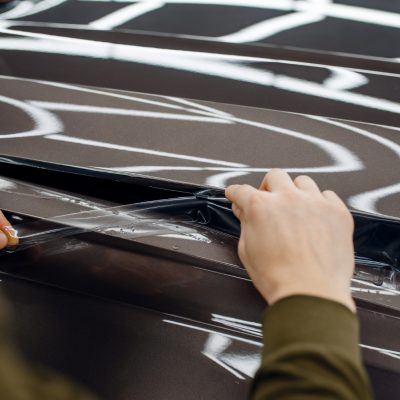 male-worker-installs-transparent-protection-film-car-hood-installation-coating-that-protects-paint-automobile-from-scratches-new-vehicle-garage-tuning-procedure