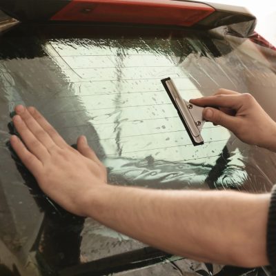 worker-applying-tinting-foil-onto-car-window